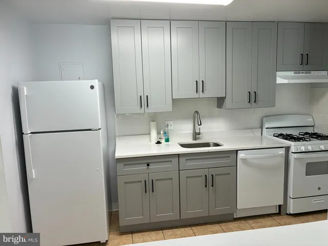 a kitchen with a sink a refrigerator and cabinets