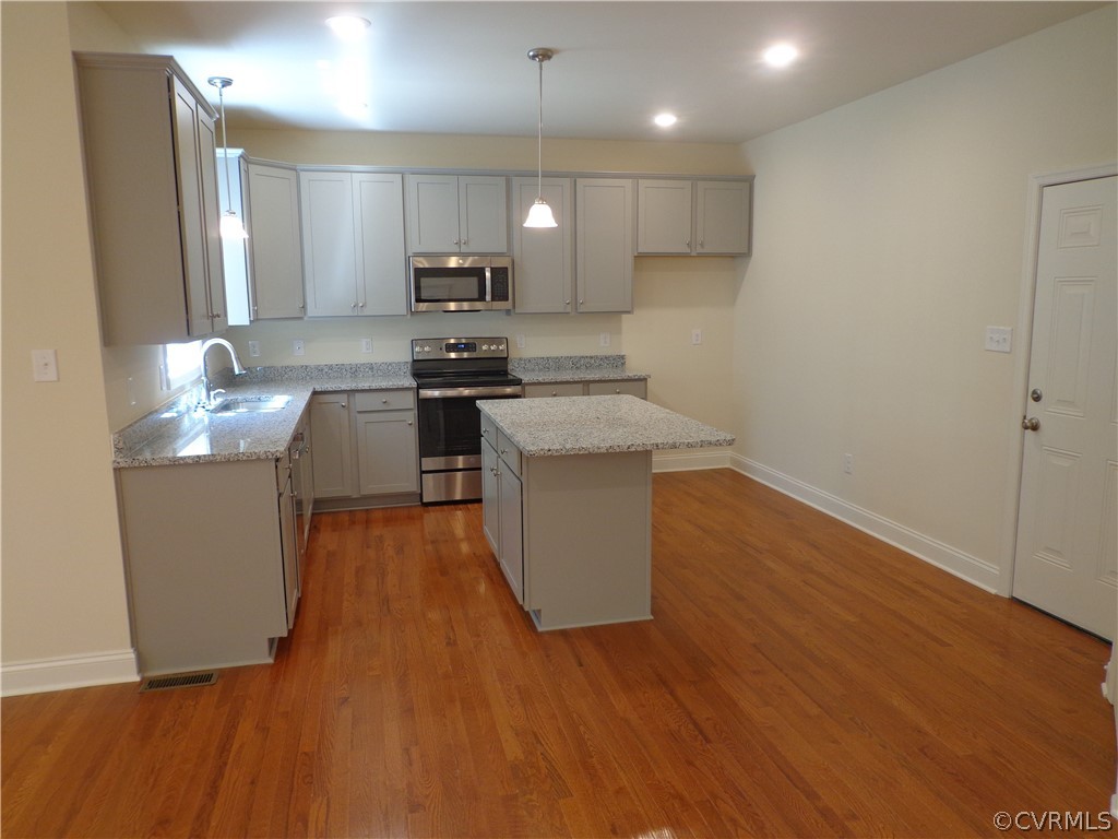 6010 Watch Harbour Road Midlothian, VA 23112 - Photo 17 of 30 a kitchen with stainless steel appliances granite countertop a sink a stove a refrigerator cabinets and wooden floor