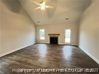 268 Brickhill Drive Raeford, NC 28376 - Photo 6 of 21 an empty room with wooden floor a ceiling fan and a fireplace