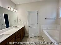 268 Brickhill Drive Raeford, NC 28376 - Photo 10 of 21 a bathroom with a granite countertop sink a mirror and a bathtub