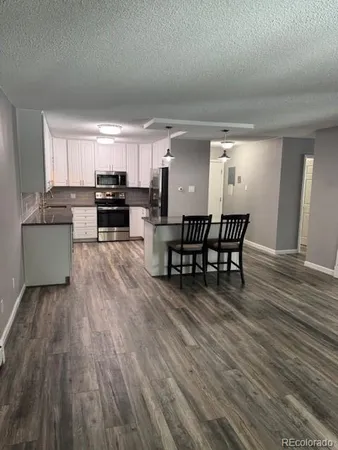 a kitchen with a table chairs and a refrigerator