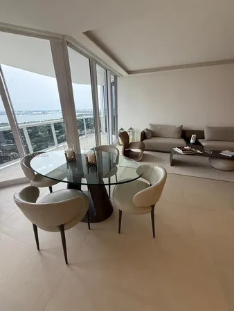 a living room with couches and a large window with rug floor