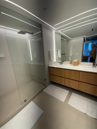 a bathroom with a double vanity sink mirror and shower