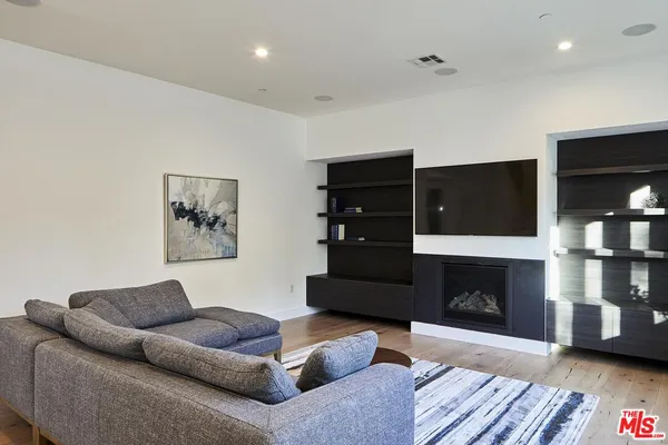 a living room with furniture a fireplace and a flat screen tv