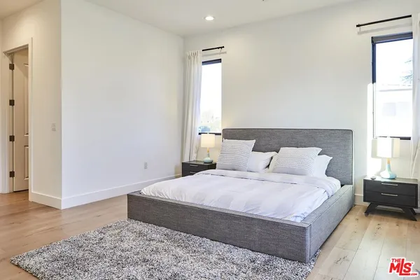 a bedroom with a bed and wooden floor