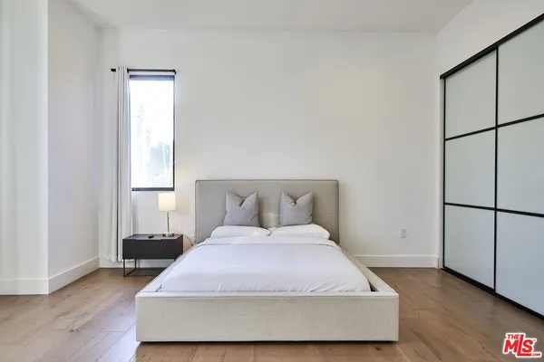 a bedroom with a bed and wooden floor