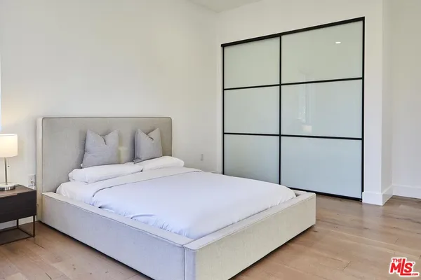 a bedroom with a bed and a large window