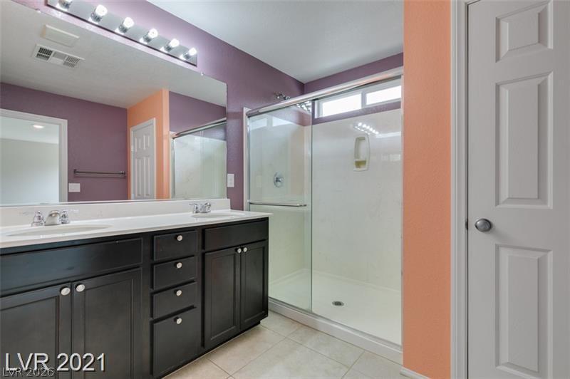 5475 Ordesa Valley Road Las Vegas, NV 89148 - Photo 11 of 35 Double vanity and a spacious walk-in shower elevate this contemporary bathroom.