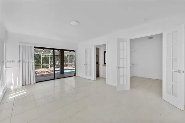 a view of an empty room with window and cabinet