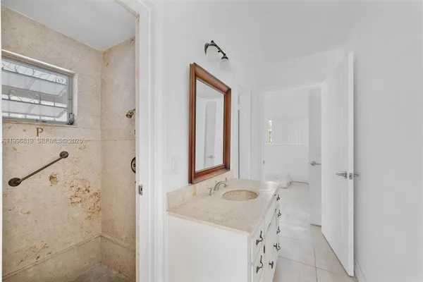a bathroom with a sink a mirror and a shower