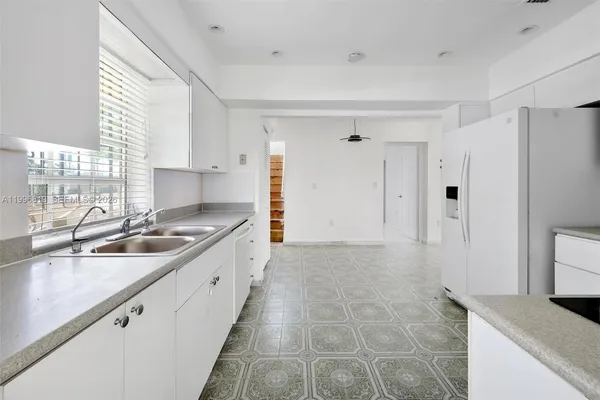 a kitchen with granite countertop a sink stove and cabinets