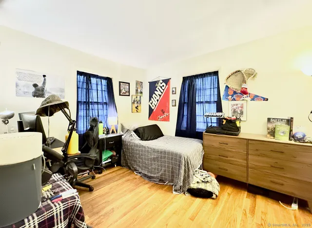 a bedroom with a bed and wooden floor