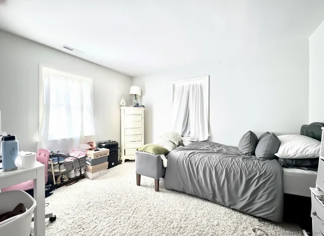 a bedroom with furniture and a large window