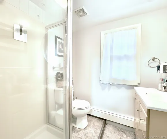 a bathroom with a granite countertop sink toilet and shower
