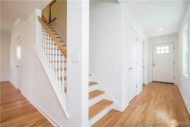 a view of a hallway with wooden floor and entryway