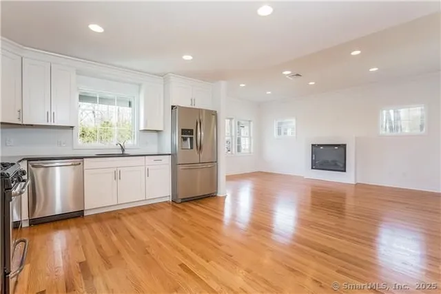 a kitchen with a refrigerator and white cabinets