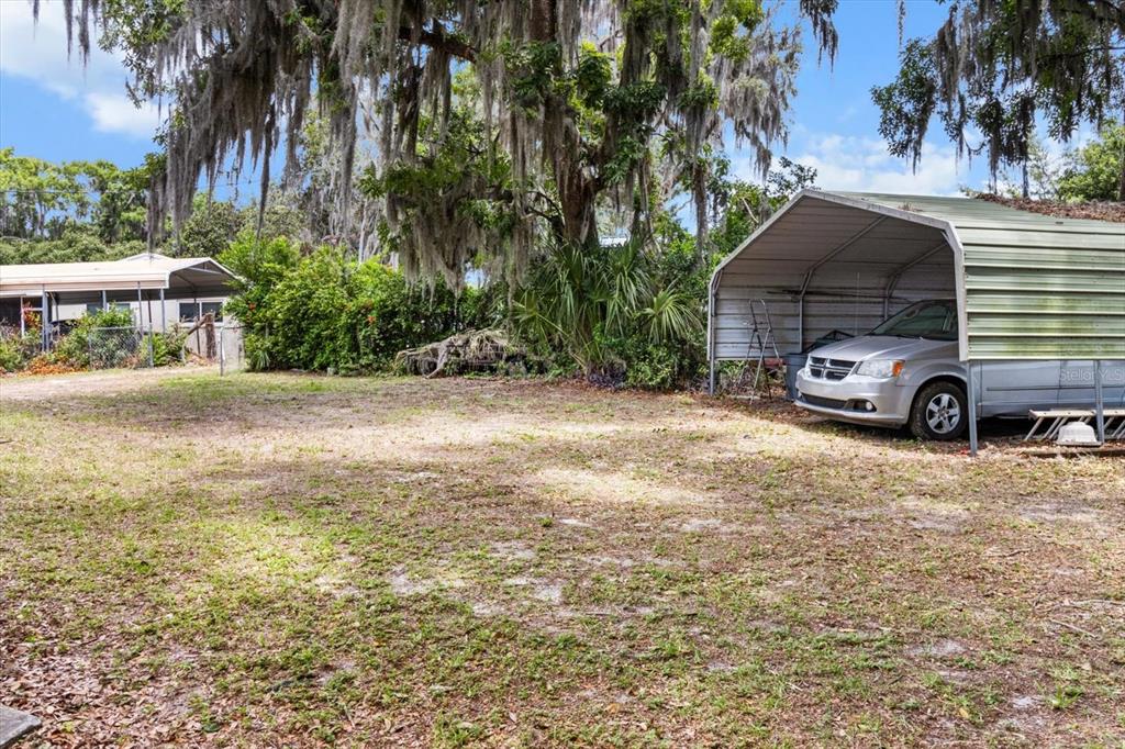 1226 South Telephone Point Road Inverness, FL 34450 - Photo 42 of 43 a car parked in front of a house and trees