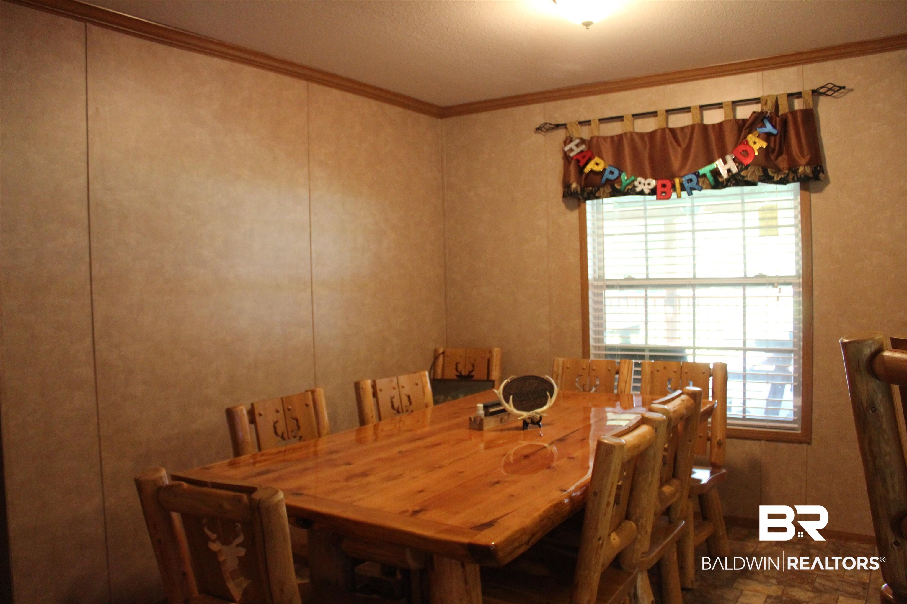 7258 Henderson Road Lowndesboro, AL 36752 - Photo 11 of 22 Dining room featuring ornamental molding, a decorative wall, and a textured ceiling