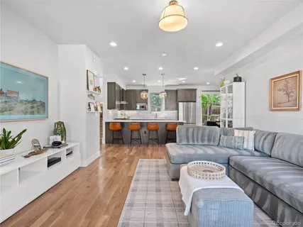 a living room with furniture kitchen view and a large window