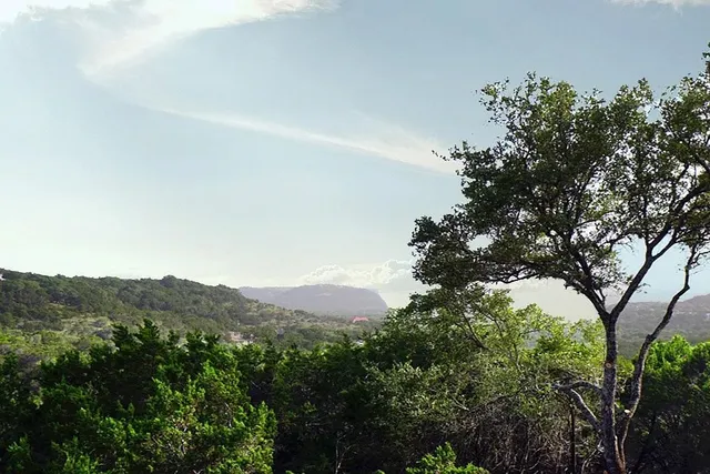a view of a mountain range with a tree in the background