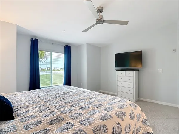 a bedroom with a large bed and a flat tv screen on dresser