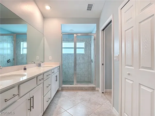 a spacious bathroom with a mirror a shower and a sink