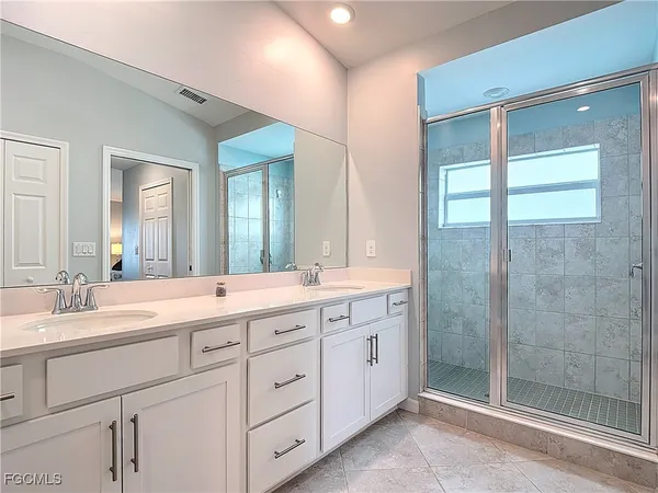 a spacious bathroom with a shower sink and mirror