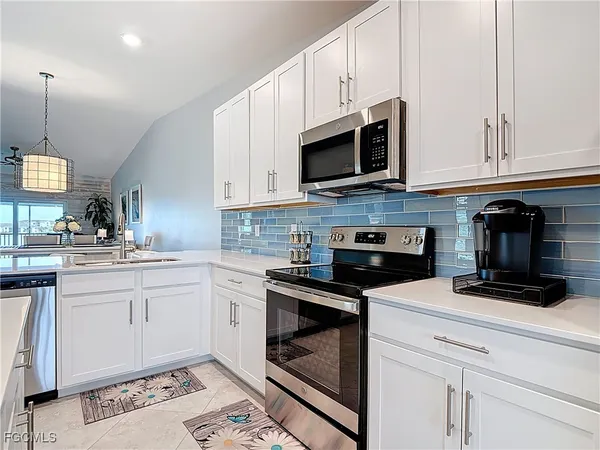 a kitchen with stainless steel appliances granite countertop a sink a stove and a microwave