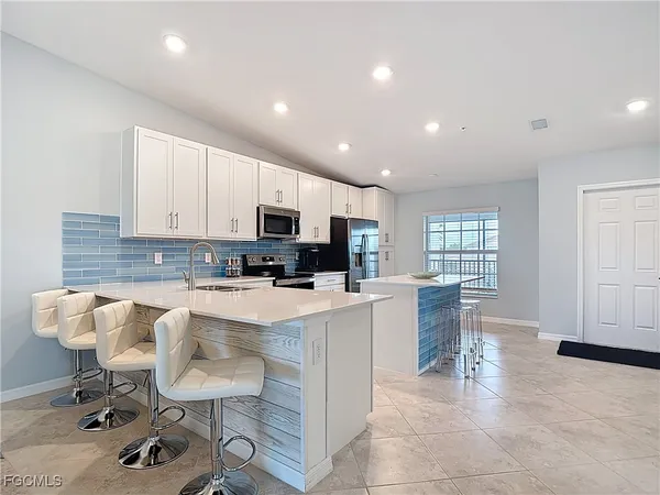 a living room with furniture a dining table and chairs with kitchen view