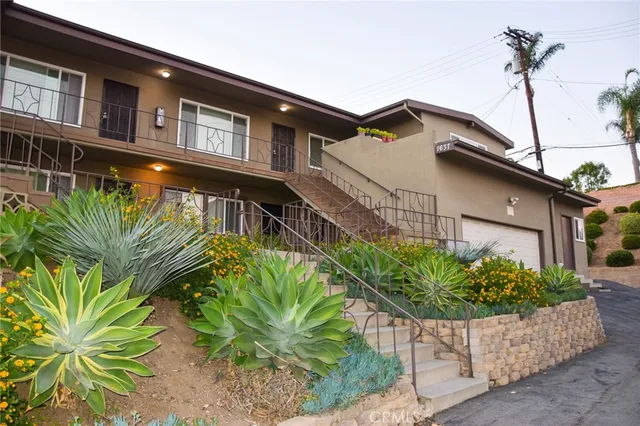 a front view of a house with a garden
