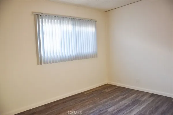 an empty room with wooden floor and closet