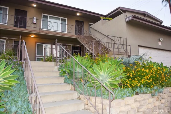 a front view of a house with a garden
