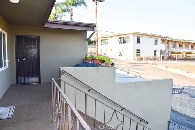 a view of a house with a tree and wooden fence