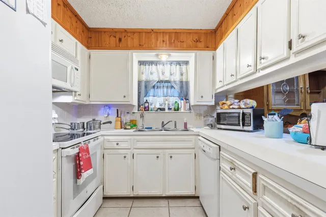 a kitchen with cabinets appliances a sink and a window