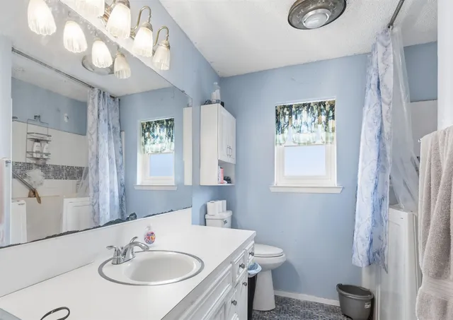 a bathroom with a sink toilet and a mirror