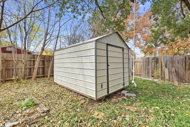 a view of a house with a yard and wooden fence