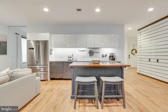 a kitchen with refrigerator a sink and chairs