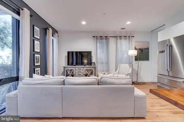 a living room with furniture a large window and a flat screen tv