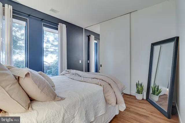 a bedroom with a bed and wooden floor