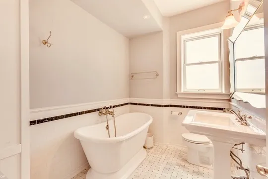a bathroom with a sink a bathtub and a window