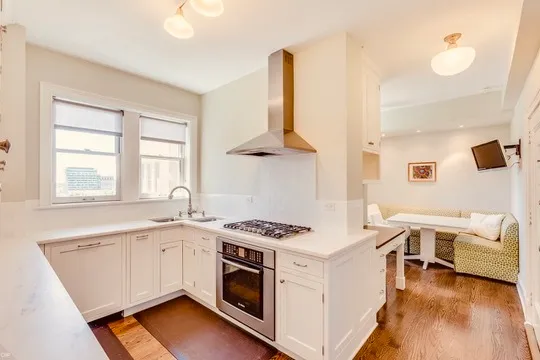 a kitchen that has a lot of cabinets in it and wooden floors