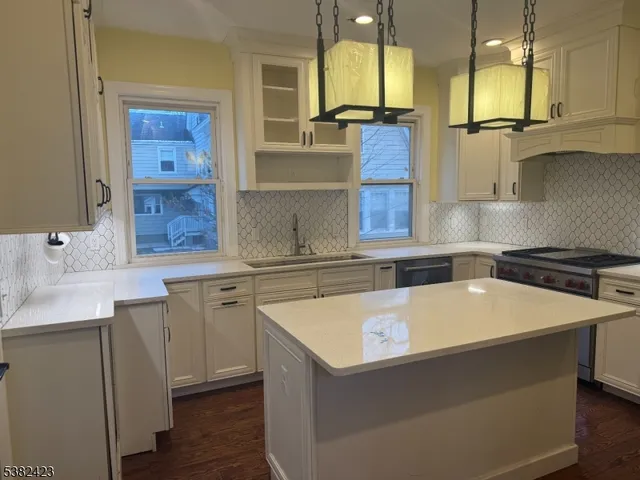 a kitchen with a sink and wooden floor
