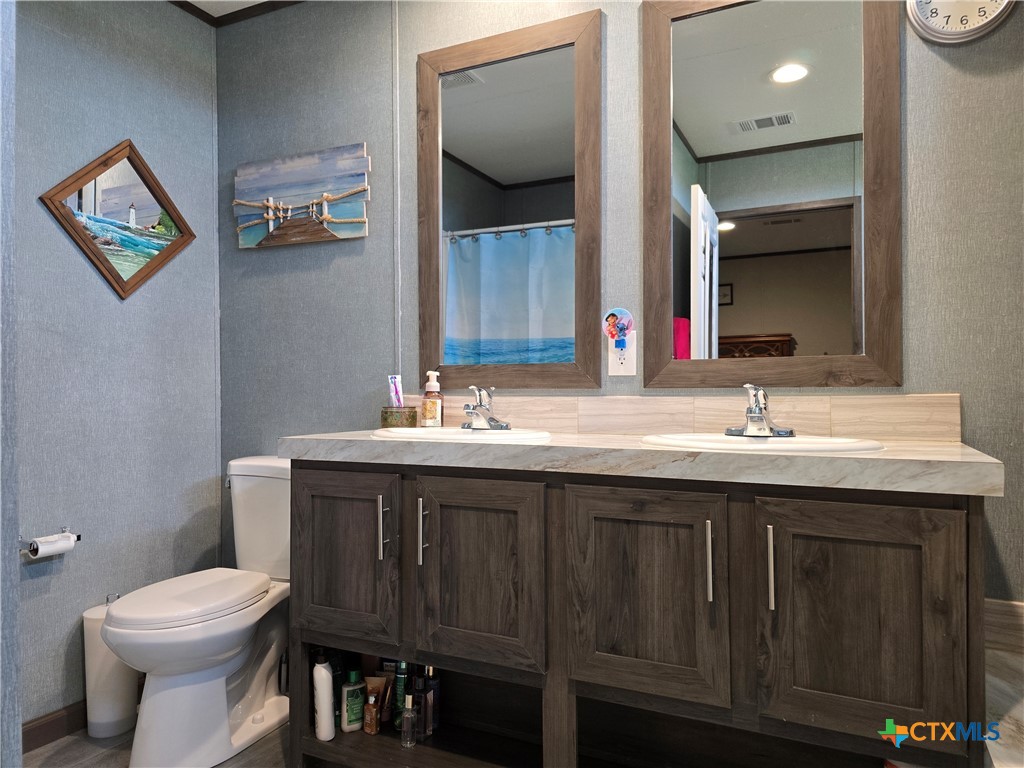 412 Coryell City Road Gatesville, TX 76528 - Photo 12 of 34 a bathroom with a toilet sink and mirror