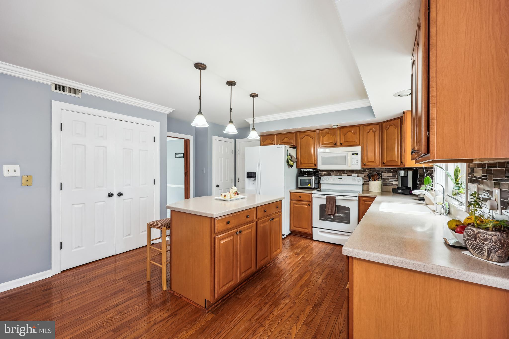 6132 Cornwall Terrace Frederick, MD 21701 - Photo 11 of 48 a kitchen with stainless steel appliances a stove top oven a sink a refrigerator and wooden floors