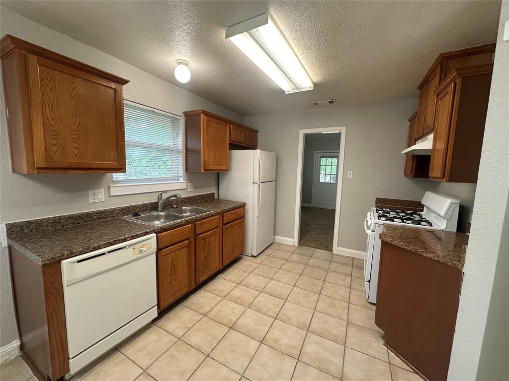 4147 Gladewater Road Dallas, TX 75216 - Photo 11 of 31 a kitchen with stainless steel appliances granite countertop a stove a sink and a refrigerator