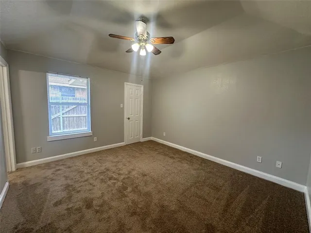 a view of an empty room with a chandelier fan