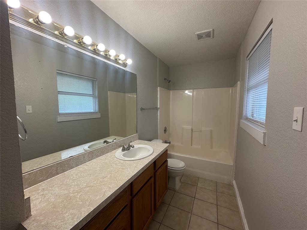 4147 Gladewater Road Dallas, TX 75216 - Photo 17 of 31 a bathroom with a sink a large mirror and a shower