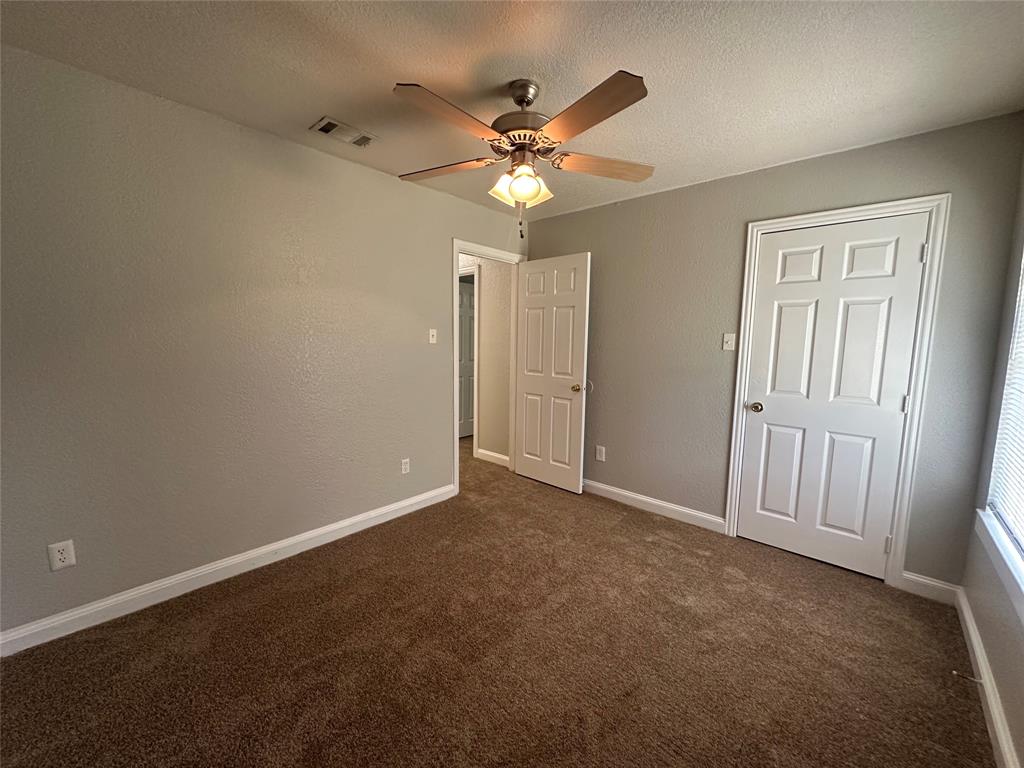 4147 Gladewater Road Dallas, TX 75216 - Photo 22 of 31 an empty room with a ceiling fan and a window
