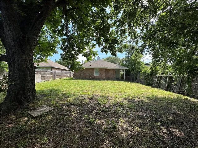 a view of a yard with a house in the background