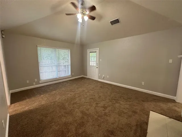 an empty room with a fireplace and fan